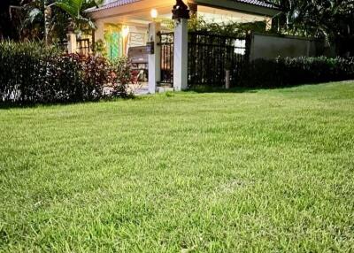 Exterior view of a two-story house at night with well-maintained lawn