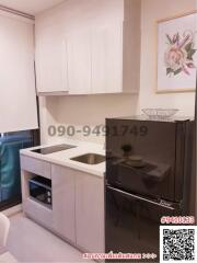 Modern compact kitchen with integrated appliances and white cabinetry in a city apartment