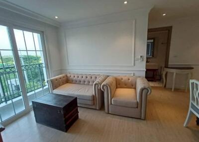 Spacious living room with large sofa and balcony access