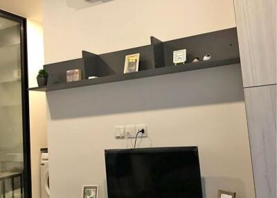 Modern living room with wall-mounted TV and shelving units