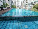 Spacious outdoor swimming pool surrounded by residential buildings
