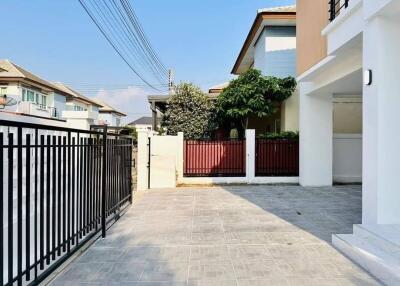 Modern residential home exterior with paved driveway and gated entry