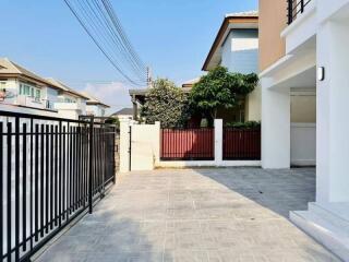 Modern residential home exterior with paved driveway and gated entry