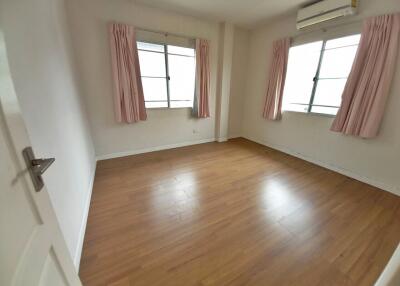 Spacious and bright bedroom with wood flooring and air conditioning unit
