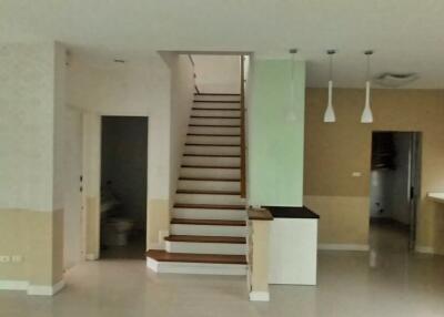 Spacious living area with modern staircase and open plan kitchen