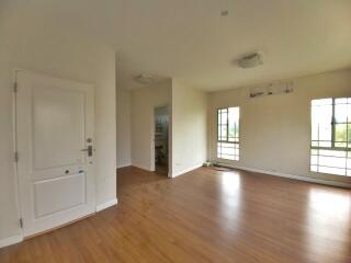 Spacious living room with hardwood flooring and large windows