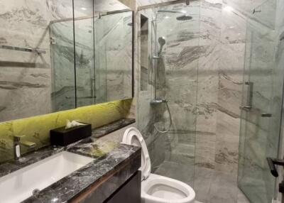 Modern bathroom with marble surfaces and glass shower enclosure