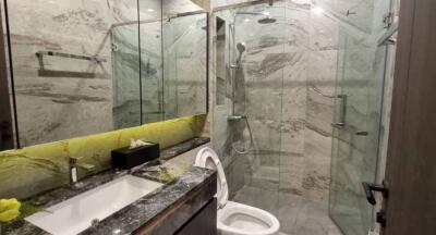 Modern bathroom with marble surfaces and glass shower enclosure