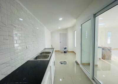 Modern kitchen with white brick backsplash and black countertop