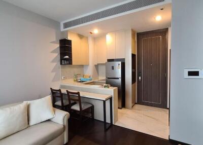 Modern living room connected to a kitchen with sleek design and comfortable seating