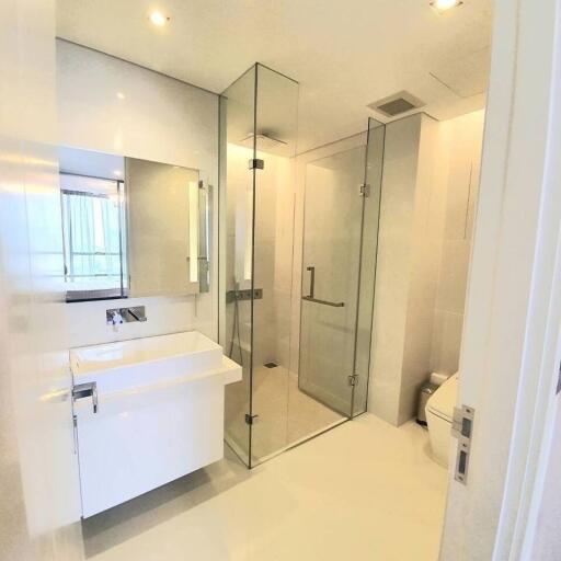 Modern bathroom interior with glass shower enclosure and white fixtures