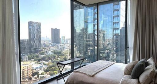 Contemporary bedroom with expansive city view through floor-to-ceiling windows