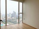 Spacious bedroom with large windows offering a panoramic city view