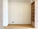 Spacious empty bedroom with wooden flooring and built-in shelving