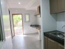 Modern kitchen with open doorway leading to a garden