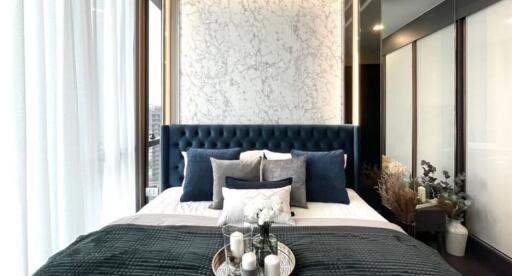 Elegant bedroom interior with a luxurious blue headboard and stylish decor