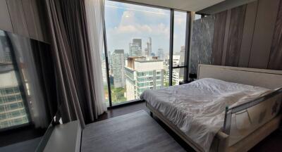 Modern bedroom with large window overlooking city