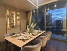 Elegantly set dining table in a modern apartment with city views at night