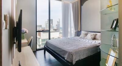 Modern bedroom with large windows and city view