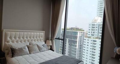 Modern bedroom interior with large window overlooking the city