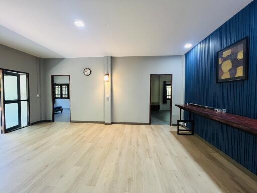 Spacious living room with modern flooring and elegant blue wall paneling