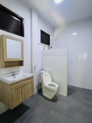 Spacious and modern bathroom with clean white tiles and wooden vanity