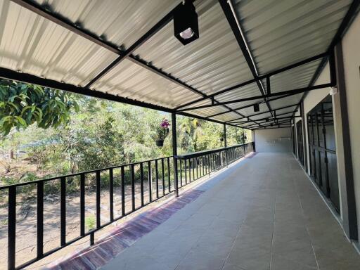 Spacious covered porch with tiled flooring and garden view