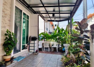 Spacious covered patio with lush greenery and comfortable seating