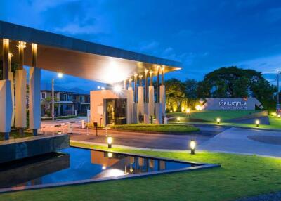 Modern residential complex entrance with ambient lighting at dusk