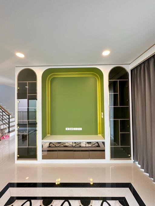 Modern living room with unique green alcove and glass doors