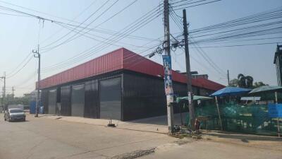 Exterior view of a modern industrial warehouse with red and black facade