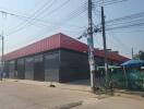 Exterior view of a modern industrial warehouse with red and black facade