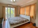 Spacious bedroom with natural light from balcony doors