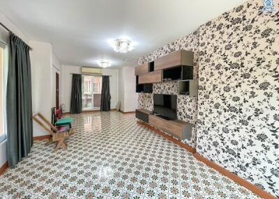 Spacious living room with decorative wallpaper and patterned tiled floor