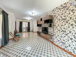 Spacious living room with decorative wallpaper and patterned tiled floor