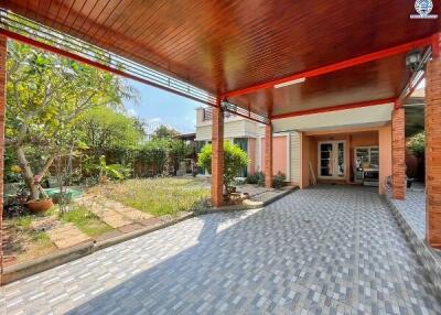 Spacious outdoor patio with covered seating area and lush garden