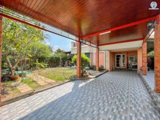 Spacious outdoor patio with covered seating area and lush garden