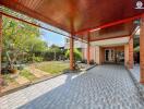 Spacious outdoor patio with covered seating area and lush garden