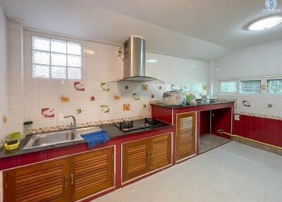 Spacious kitchen with red cabinets and modern appliances