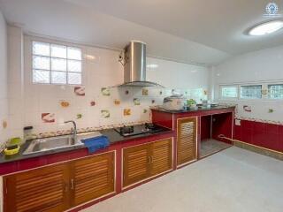 Spacious kitchen with red cabinets and modern appliances