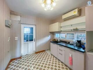 Spacious kitchen with modern appliances and vintage floor tiles