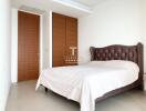 Spacious and modern bedroom with large bed and elegant wooden door