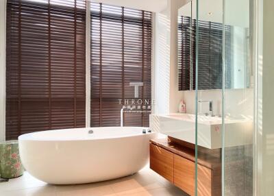 Modern bathroom with a freestanding tub and wooden blinds