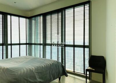 Modern bedroom with full-length windows overlooking the ocean