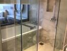 Elegant bathroom with glass shower enclosure and view of bathtub