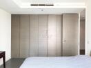 Modern bedroom with large padded wall panels and a minimalistic design