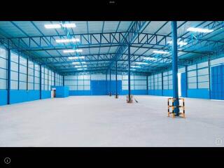 Spacious industrial warehouse interior with blue walls and high ceiling