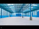 Spacious industrial warehouse interior with blue walls and high ceiling