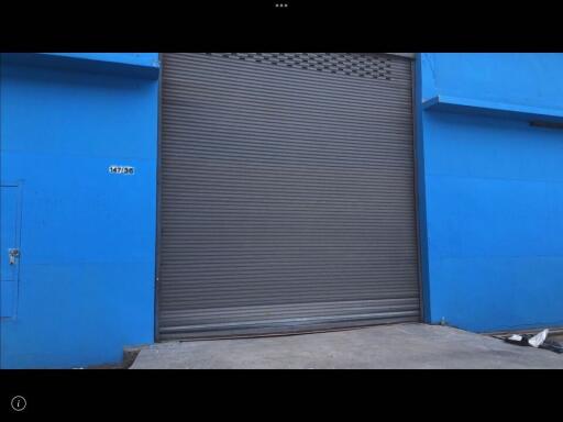Blue commercial building facade with a large metal shutter