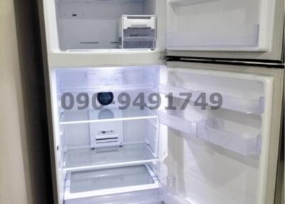 Open modern refrigerator in kitchen showcasing empty shelves and compartments